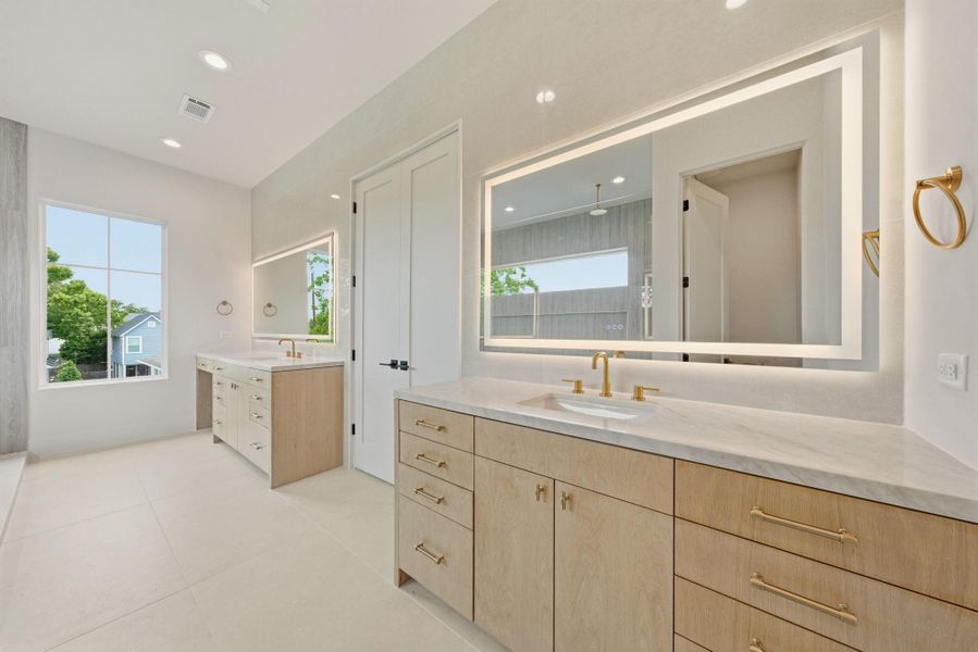 Smart LED mirrors, dual vanities, custom cabinetry elevate this relaxing experience.