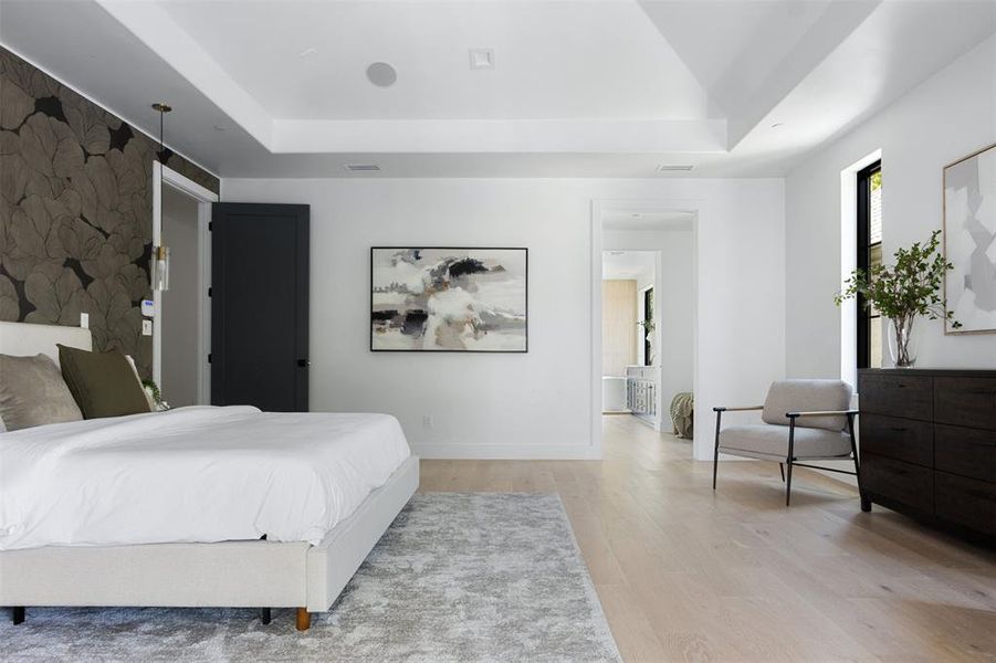 Bedroom featuring a raised ceiling and light hardwood / wood-style flooring