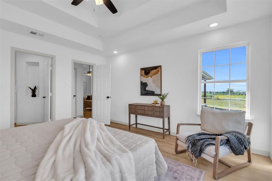 Bedroom with a raised ceiling, wood finished floors, recessed lighting, and ceiling fan Bedroom with a raised ceiling, wood finished floors, recessed lighting, and ceiling fan