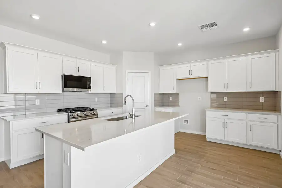 A kitchen with white cabinets.