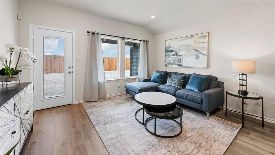 Living area with lofted ceiling, recessed lighting, and light wood-type flooring Living area with lofted ceiling, recessed lighting, and light wood-type flooring