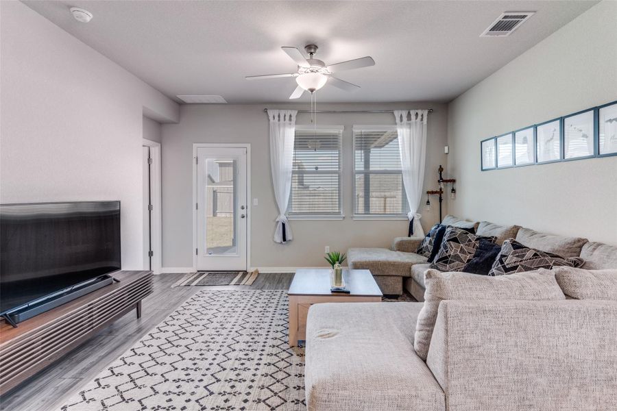 Living area with light wood-style flooring and ceiling fan
