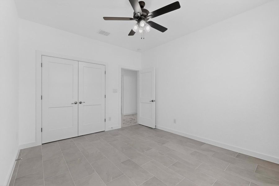 Unfurnished bedroom featuring ceiling fan and a closet