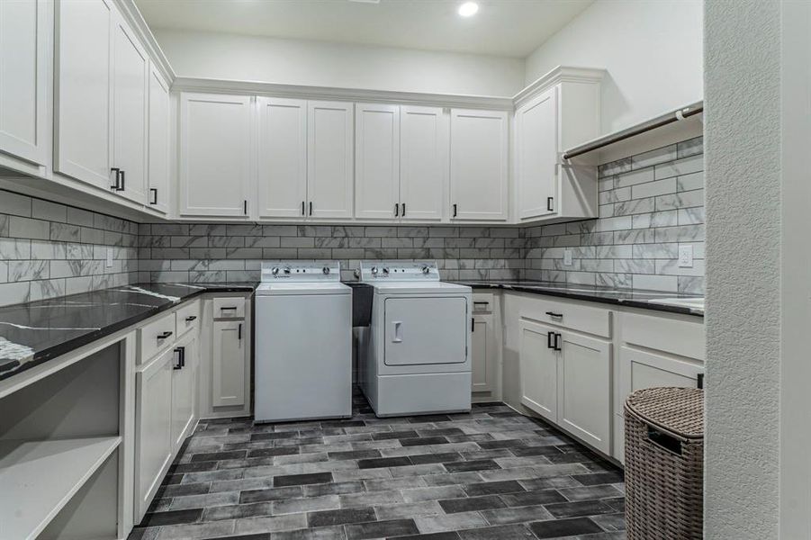 Laundry area featuring washing machine and dryer, cabinet space, and recessed lighting Laundry area featuring washing machine and dryer, cabinet space, and recessed lighting