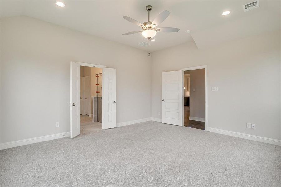 Unfurnished bedroom with lofted ceiling, carpet flooring, and ceiling fan