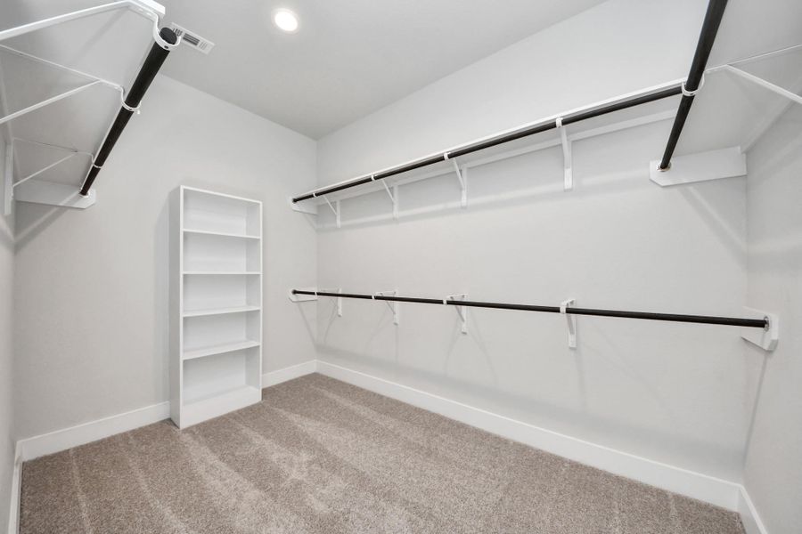 Walk-in closet that epitomizes luxury and practicality. This generously sized space features built-in shelving, offering abundant room for impeccable organization. High ceilings and recessed lighting create a bright and welcoming ambiance.