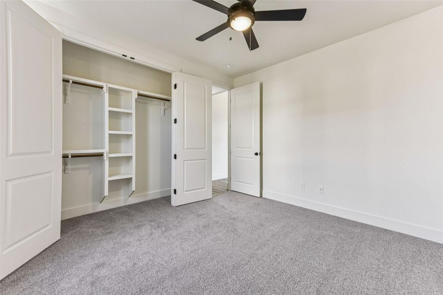 Unfurnished bedroom featuring light carpet, a ceiling fan, and a closet