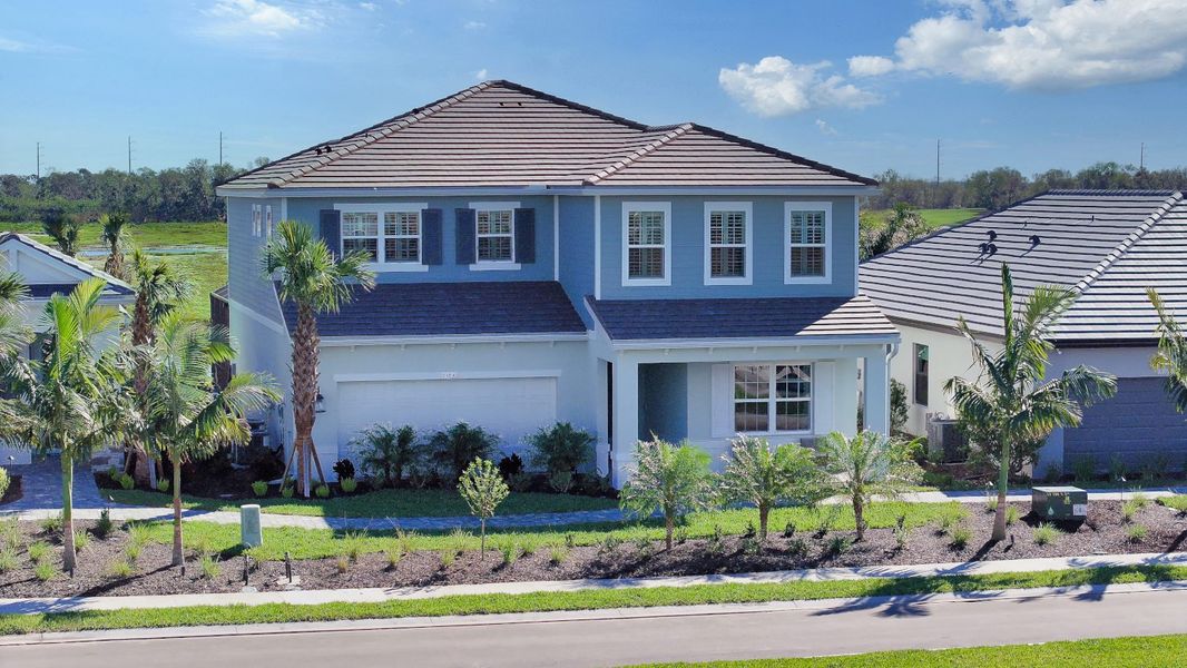 Front exterior of a new home in Palm Grove, Lakewood Ranch, FL, highlighting curb appeal (Image 23).
