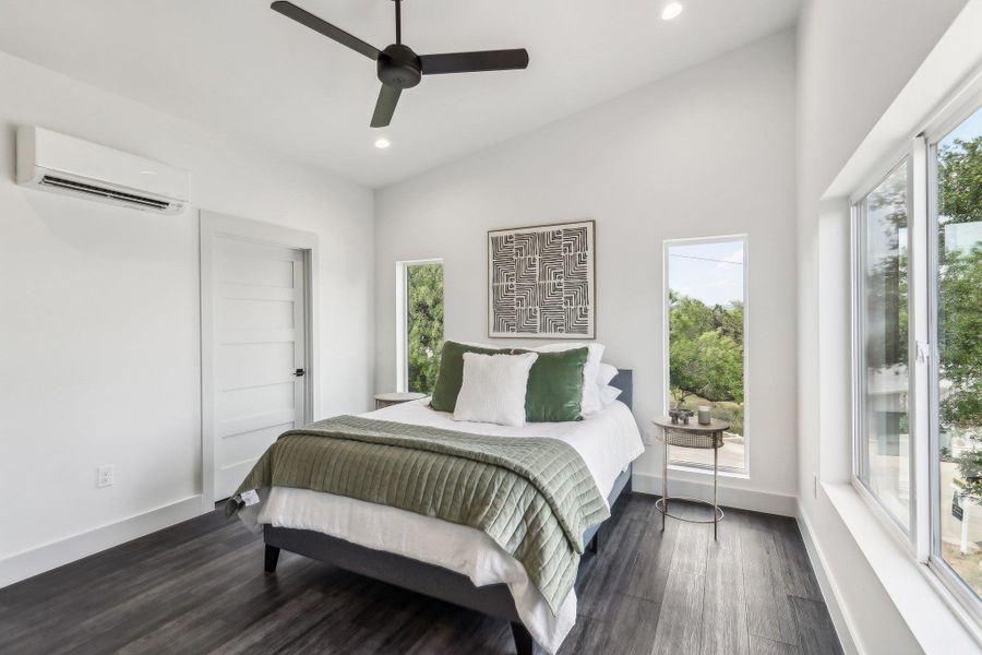 Bedroom featuring a wall mounted air conditioner, recessed lighting, dark wood-type flooring, baseboards, and a ceiling fan Bedroom featuring a wall mounted air conditioner, recessed lighting, dark wood-type flooring, baseboards, and a ceiling fan