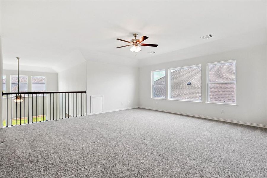 Carpeted spare room with a healthy amount of sunlight and ceiling fan