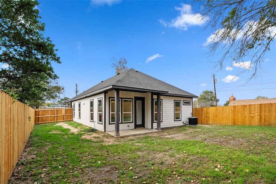 Rear view of house with a patio area, a fenced backyard, and roof with shingles