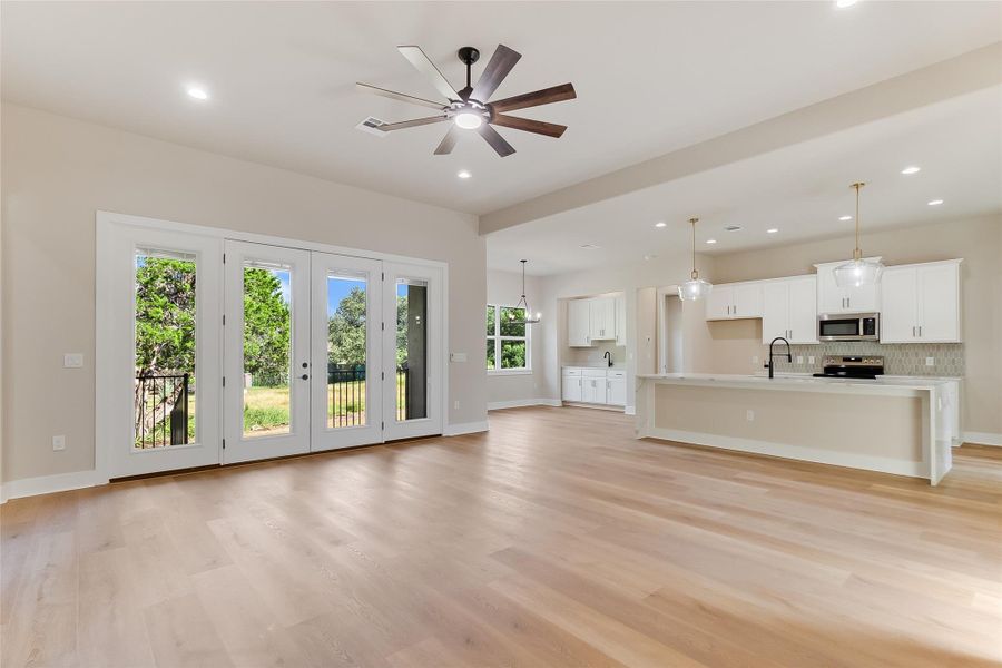 Unfurnished living room with light wood finished floors, recessed lighting, and ceiling fan Unfurnished living room with light wood finished floors, recessed lighting, and ceiling fan