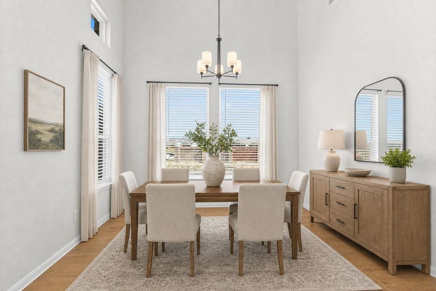 Elegant dining area located just off the entry and perfectly positioned near the gourmet kitchen for effortless entertaining. This inviting space features beautiful wood looking tile flooring and large windows that allow natural light to fill the room, creating a warm setting for family meals and gatherings. *Photo is Virtually Staged*