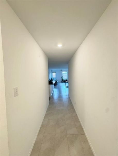 Corridor with baseboards and light tile patterned flooring