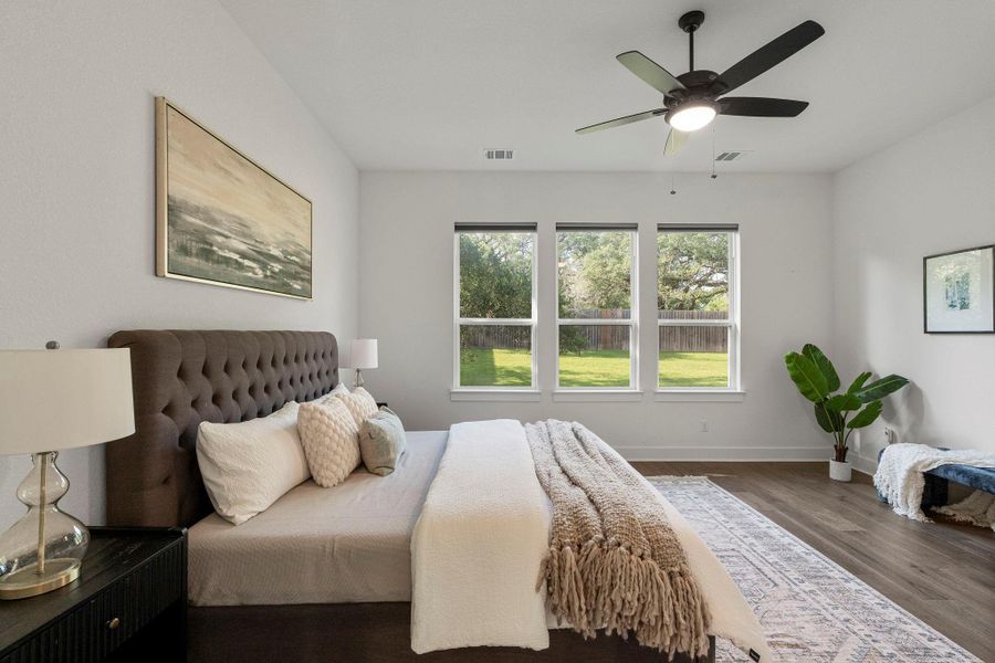 A tranquil haven with a ceiling fan, offering views of a verdant outdoor landscape from generous windows.