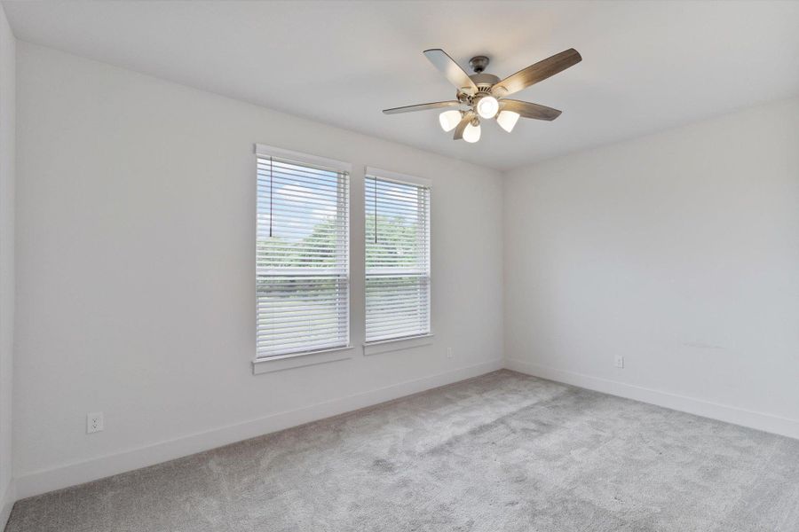 Spare room with light carpet and a ceiling fan