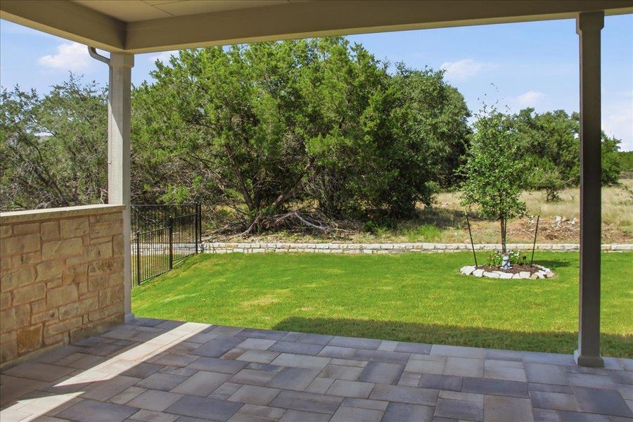 An inviting covered patio offers a private outdoor retreat overlooking a fenced green space and natural landscape. An inviting covered patio offers a private outdoor retreat overlooking a fenced green space and natural landscape.