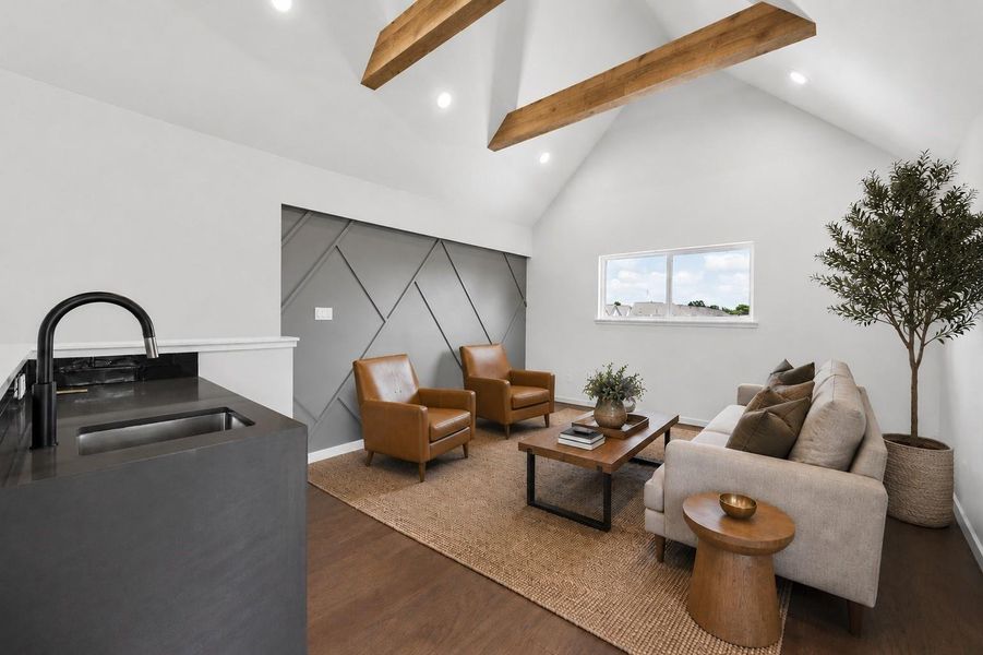 Versatile game room featuring soaring vaulted ceilings, exposed wood beams, a designer accent wall, and a built-in wet bar for effortless entertaining. Versatile game room featuring soaring vaulted ceilings, exposed wood beams, a designer accent wall, and a built-in wet bar for effortless entertaining.