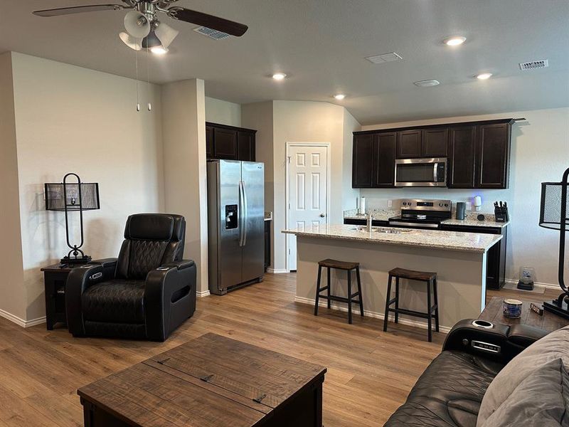 Living area with light wood-style flooring, recessed lighting, and a ceiling fan