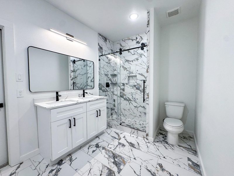 This spacious bathroom features dual sinks, a large mirror, and plenty of counter space — perfect for busy mornings or relaxing evening routines. This spacious bathroom features dual sinks, a large mirror, and plenty of counter space — perfect for busy mornings or relaxing evening routines.