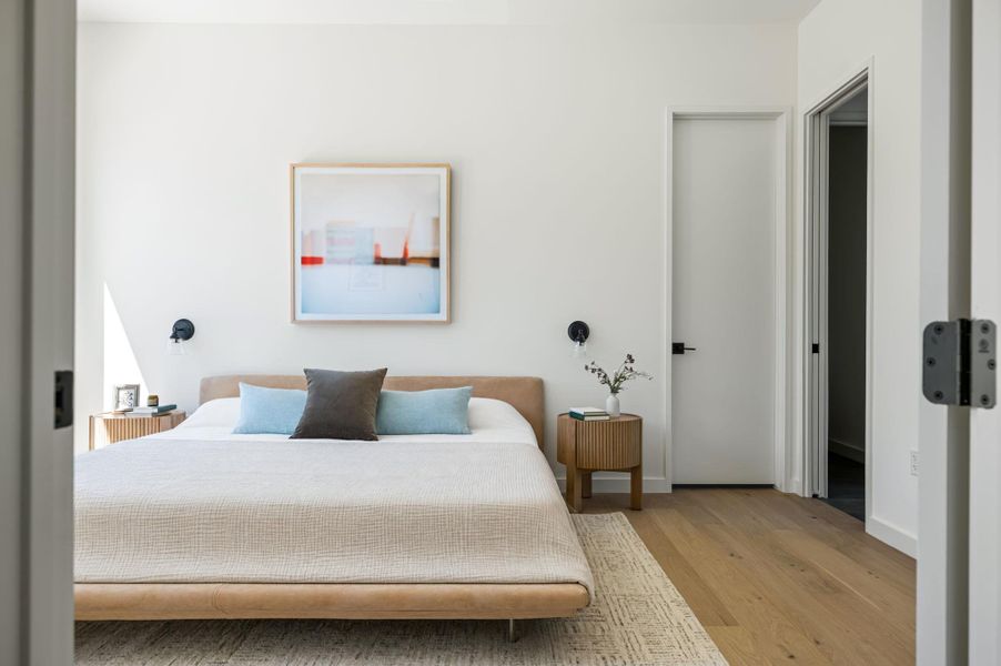 Smooth plaster walls and warm oak flooring create a serene and minimalist sleeping sanctuary.