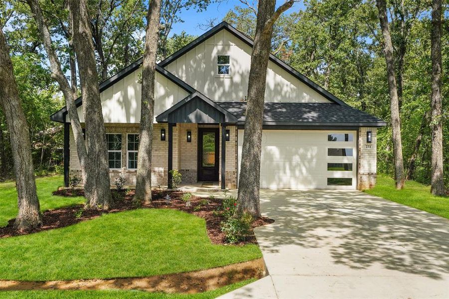Modern farmhouse-style exterior featuring a light brick facade and dark trim accents Modern farmhouse-style exterior featuring a light brick facade and dark trim accents