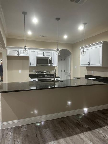 Kitchen featuring white cabinets and hanging light fixtures