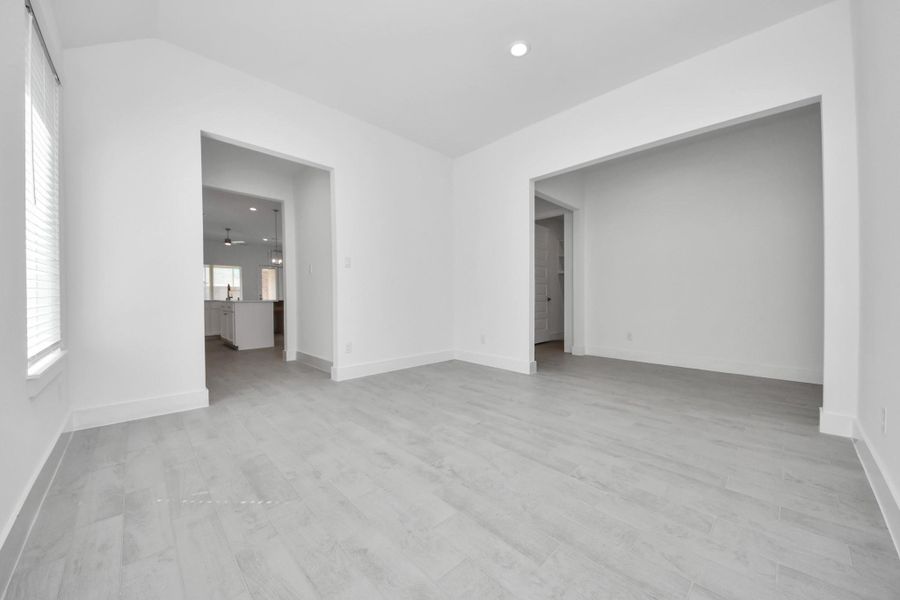 Create lasting memories with your family and friends at the dining table! This expansive dining room showcases sophisticated flooring, custom paint, and seamlessly connects to the family room and kitchen, providing an open and inviting atmosphere.