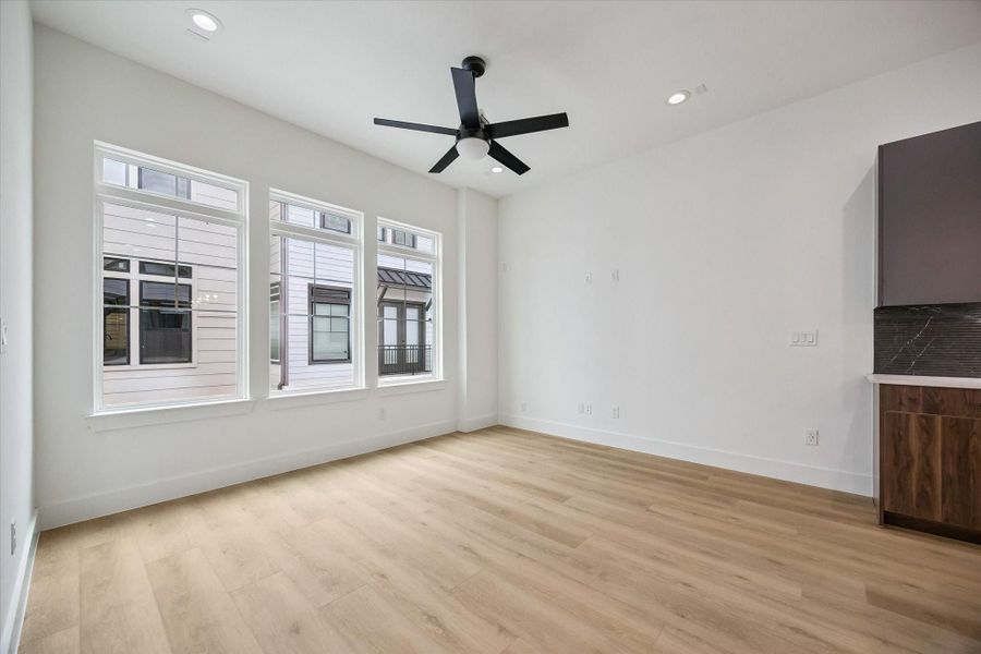 Spacious bedroom retreat with large windows and ceiling fan