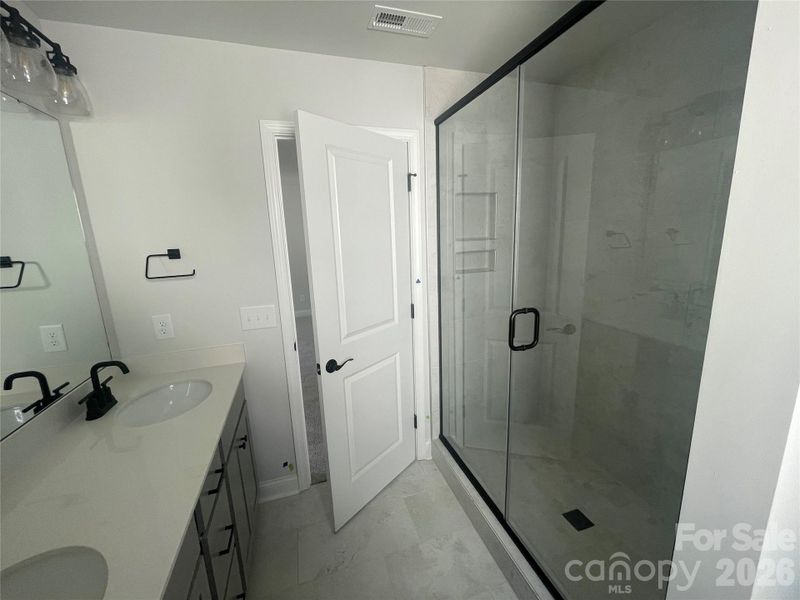 Walk in shower with soap niche and tile to the ceiling