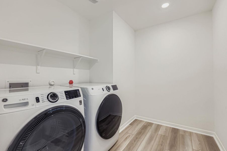 Laundry room with light wood-type flooring, recessed lighting, and washing machine and clothes dryer Laundry room with light wood-type flooring, recessed lighting, and washing machine and clothes dryer
