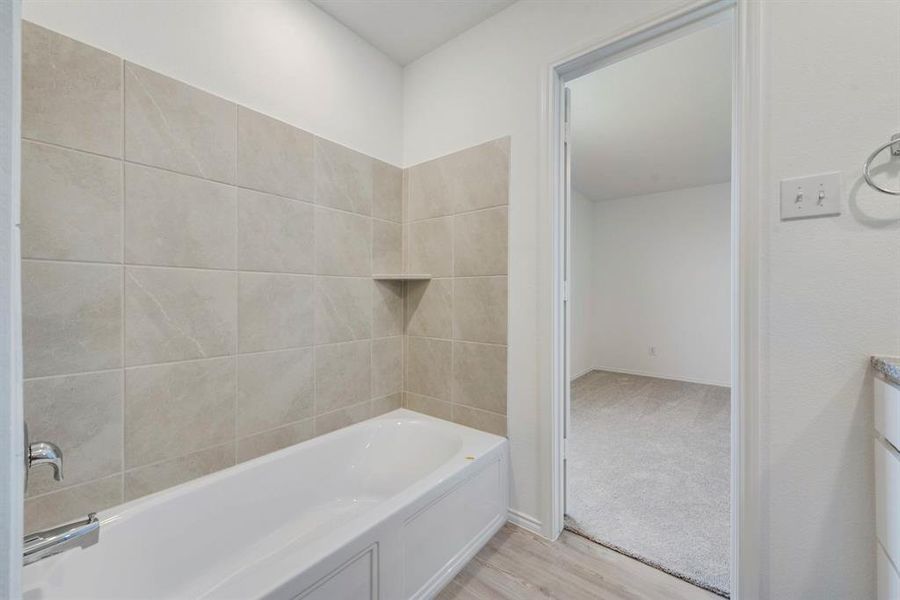 Bathroom featuring tiled shower / bath combo and hardwood / wood-style floors