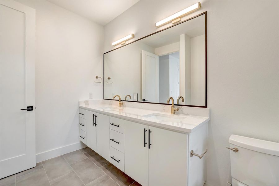 Bathroom featuring double vanity and tile patterned flooring Bathroom featuring double vanity and tile patterned flooring