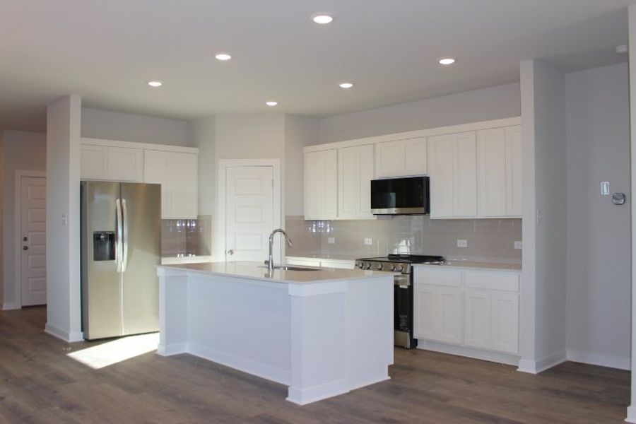 A kitchen with white cabinets.