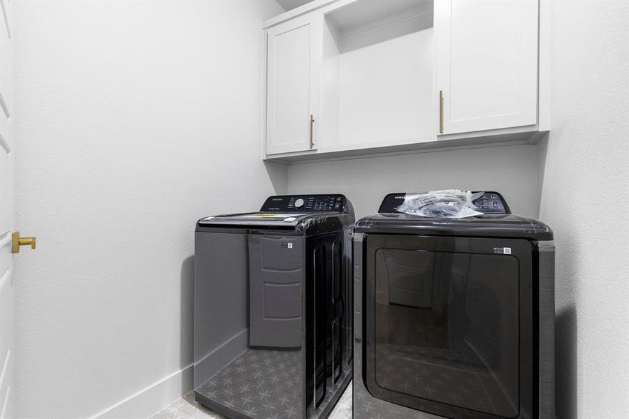 Washroom with cabinets, independent washer and dryer, and light tile patterned floors