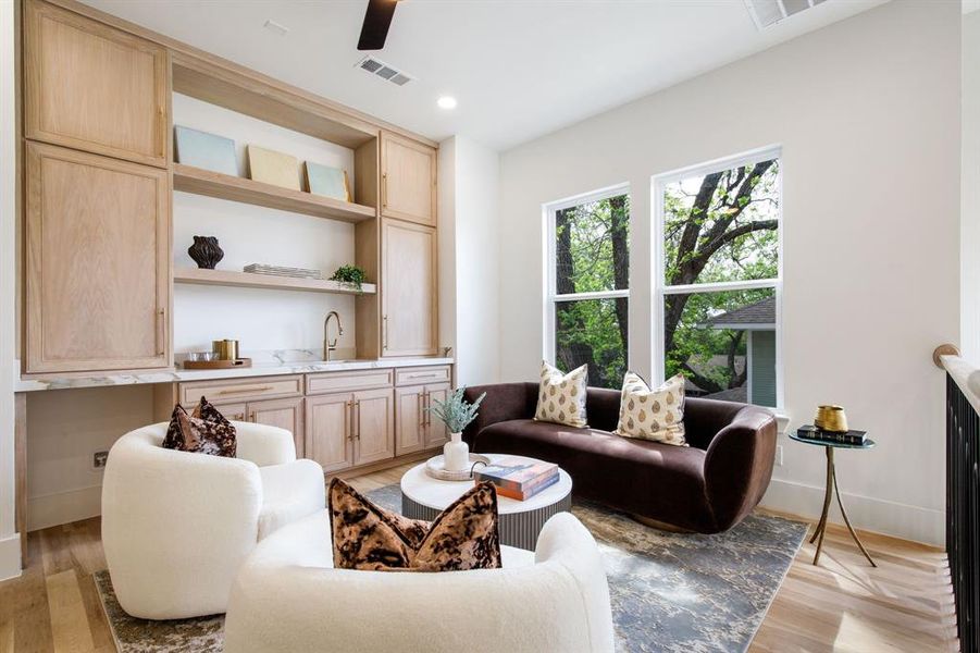 Built-in cabinetry with open shelving and a wet bar featuring a brass faucet and stone countertop Built-in cabinetry with open shelving and a wet bar featuring a brass faucet and stone countertop