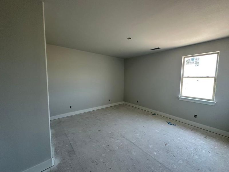 Bright room with a single window, light-colored walls, and a recessed ceiling light