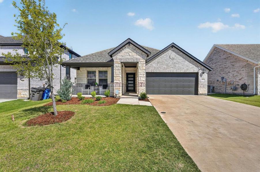 Contemporary single-story residence featuring a stone and brick exterior with dark trim Contemporary single-story residence featuring a stone and brick exterior with dark trim