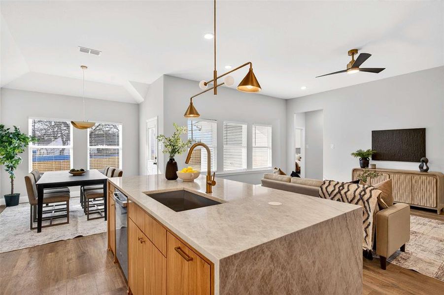 Kitchen with light stone counters, pendant lighting, dark wood-type flooring, open floor plan, and healthy amount of natural light