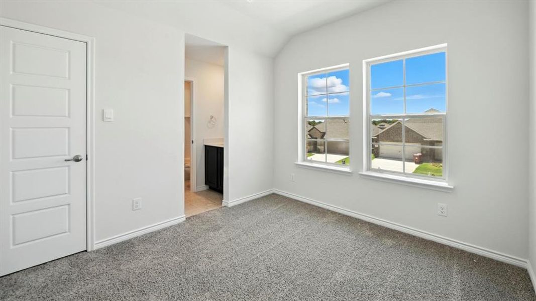 Unfurnished bedroom featuring ensuite bath and light colored carpet