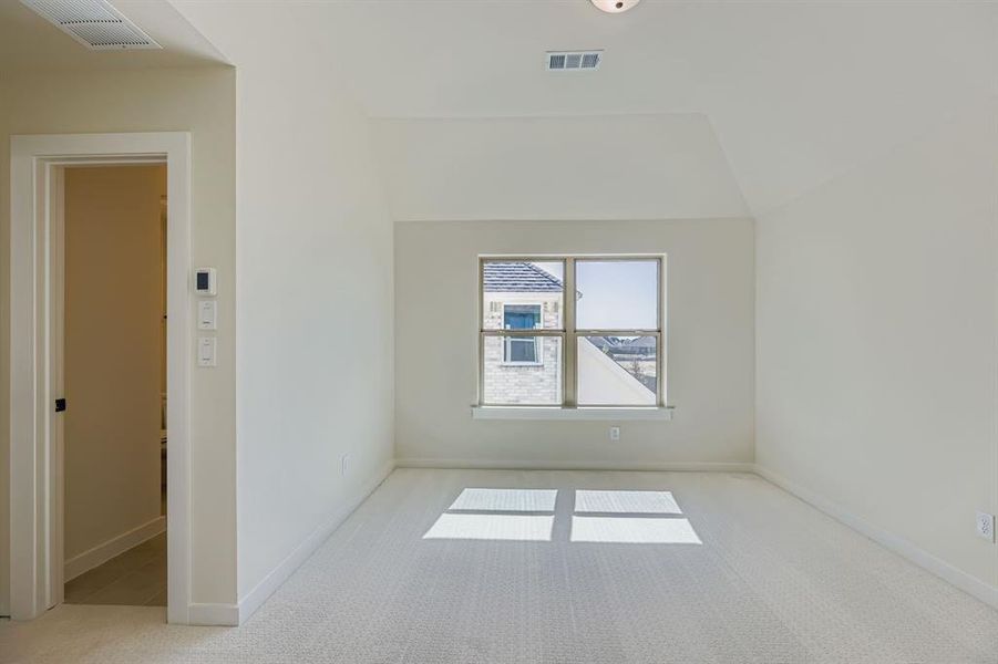 Unfurnished room featuring light carpet and baseboards