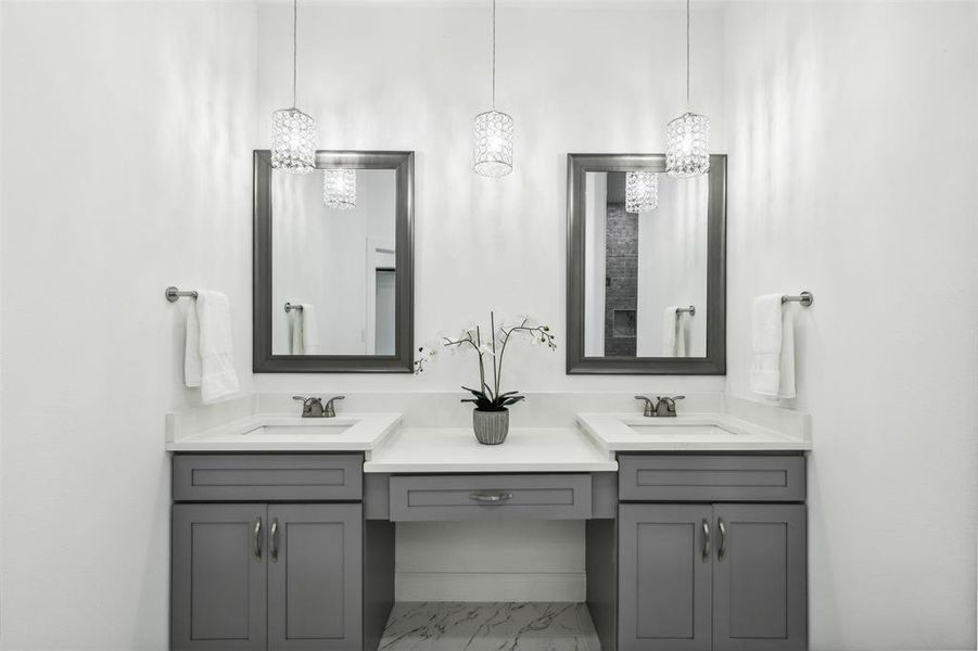 Bathroom featuring dual vanity, tile patterned flooring, and an inviting chandelier