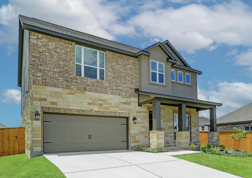 Angled exterior photo of the Brazos, featuring a two-car garage, exquisite stone and brick, and a covered front porch.