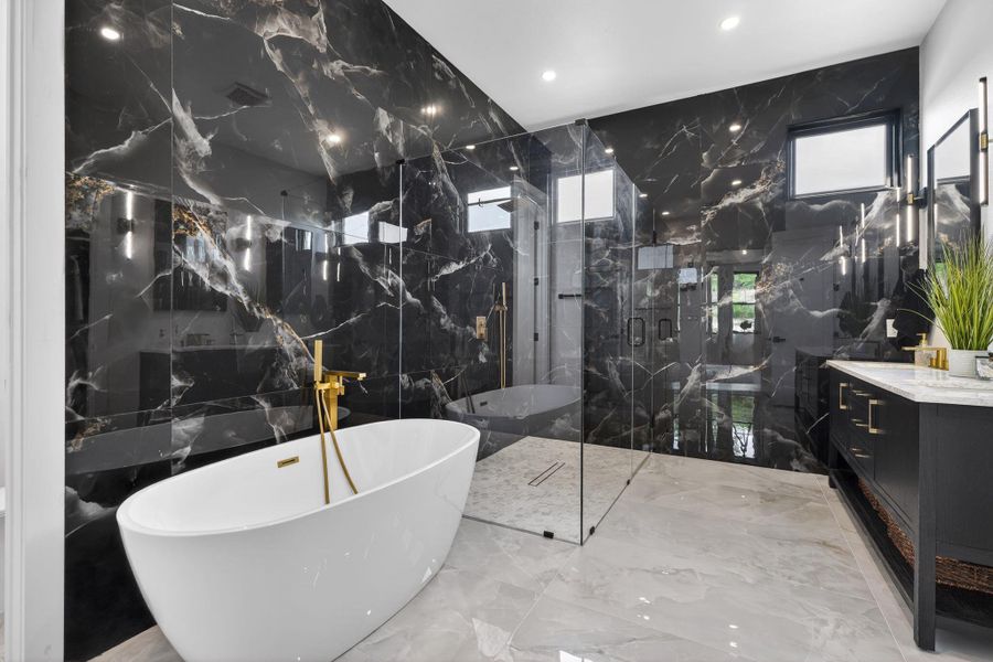 Bathroom with stone wall, tile walls, a soaking tub, vanity, and light marble finish floors