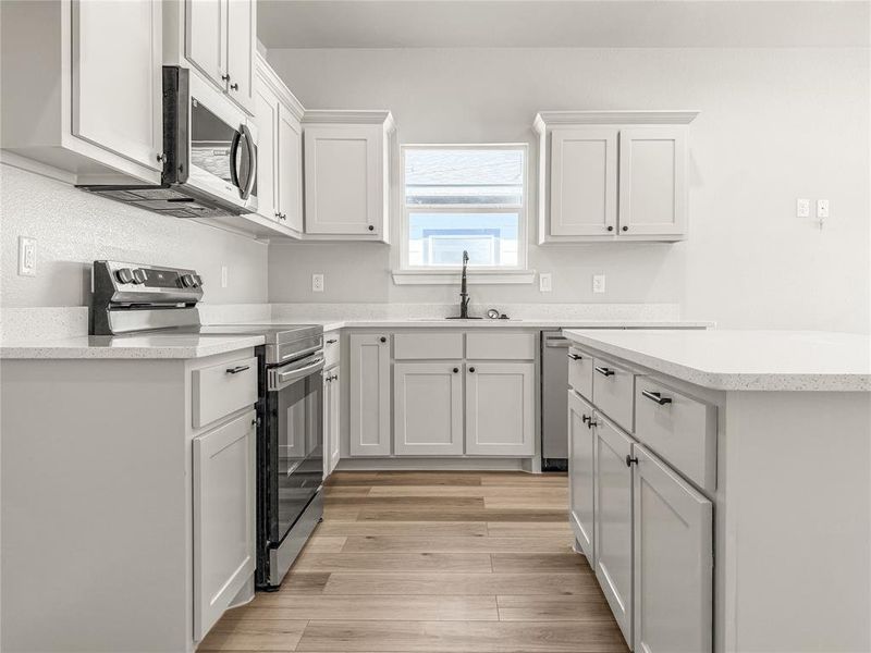 Modern kitchen featuring a central island with countertop seating space Modern kitchen featuring a central island with countertop seating space