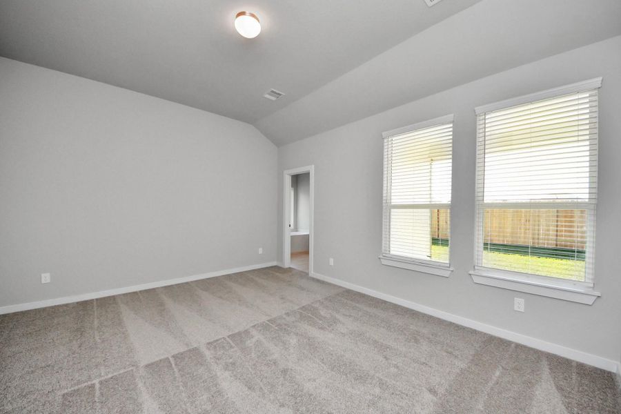 Escape to tranquility in this spacious primary room, adorned with plush carpeting and bathed in the soothing hues of warm paint colors, creating a cozy retreat for relaxation. Sample photo of completed home with similar floor plan. Actual colors and selections may vary. Escape to tranquility in this spacious primary room, adorned with plush carpeting and bathed in the soothing hues of warm paint colors, creating a cozy retreat for relaxation. Sample photo of completed home with similar floor plan. Actual colors and selections may vary.