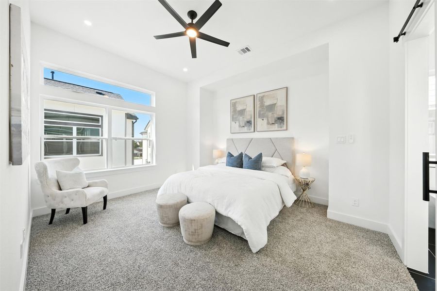 Serene and spacious primary bedroom with a clean, modern design, featuring plush carpet, high ceilings, and large windows that fill the room with natural light. Serene and spacious primary bedroom with a clean, modern design, featuring plush carpet, high ceilings, and large windows that fill the room with natural light.