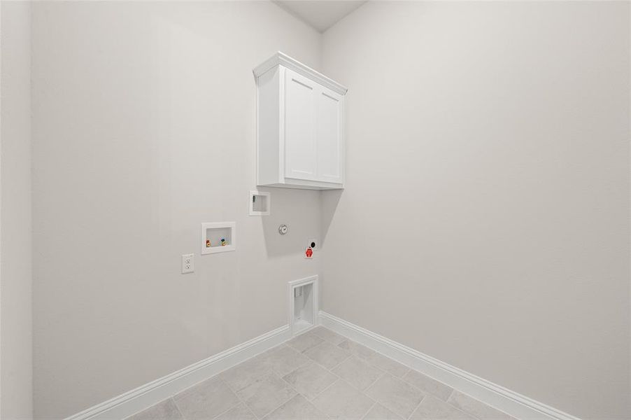 Laundry room featuring gas dryer hookup, hookup for a washing machine, cabinet space, and hookup for an electric dryer
