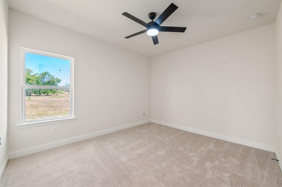Unfurnished room featuring light carpet, a smoke detector, and ceiling fan