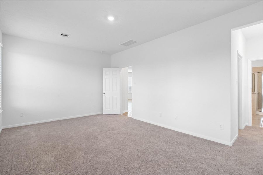 Additional view from primary bedroom looking down hallway to walk-in closet and primary bathroom.
